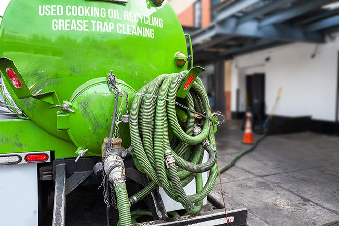 worker pumping grease trap at commercial kitchen in Bolingbrook